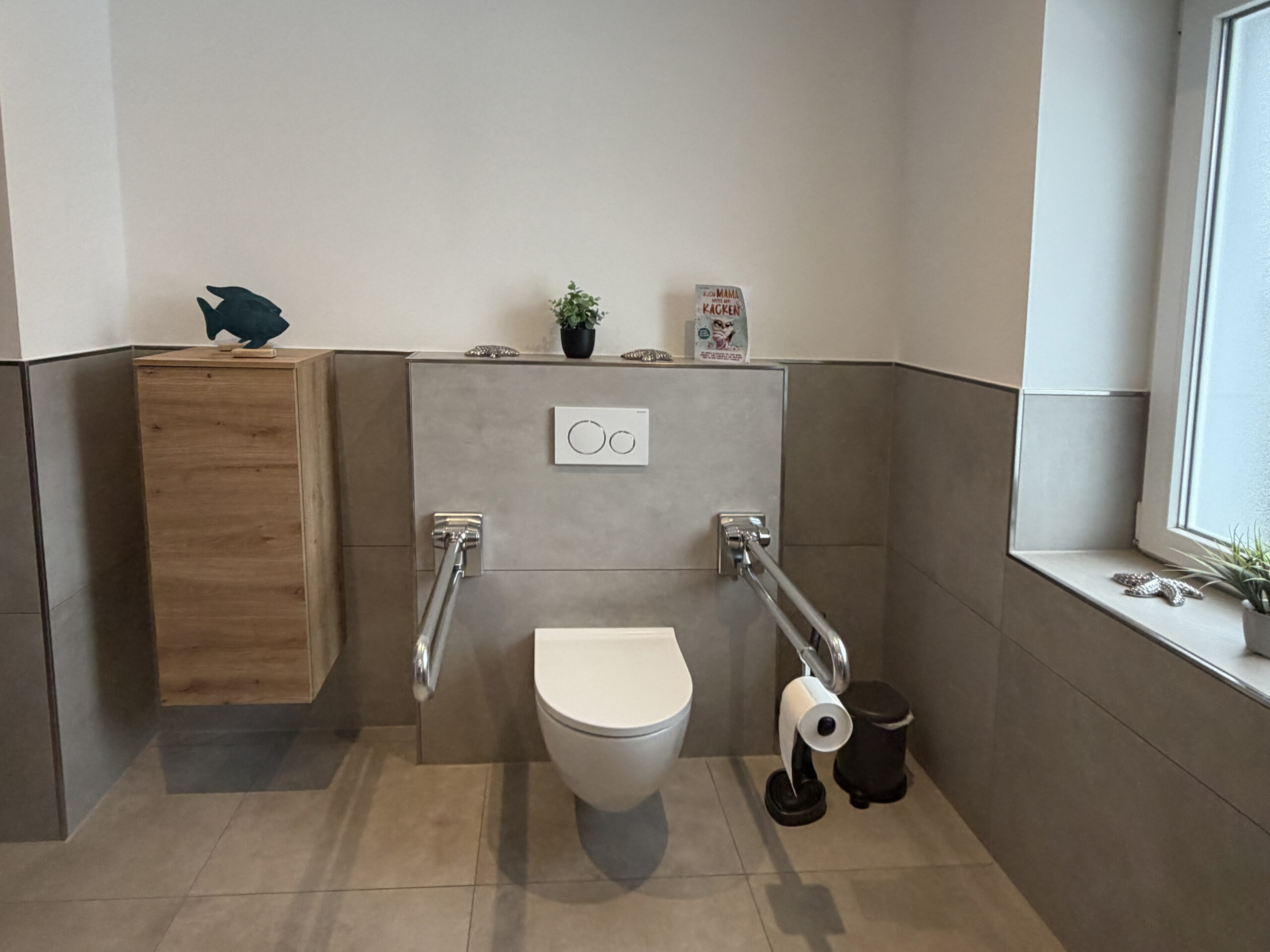 Barrierearmes Badezimmer mit WC und klappbaren Stützgriffen